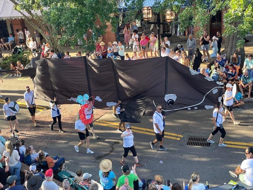 A parade display of a North Atlantic right whale is swimming down the street